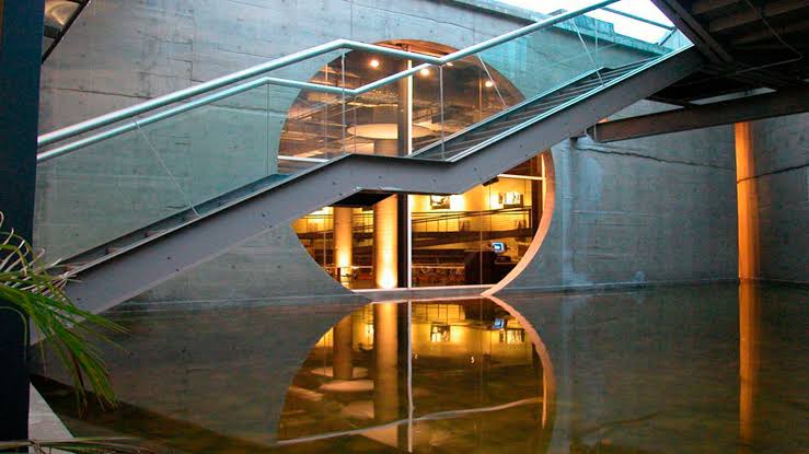 Interior do Unibes Cultural com escada e espelho d'água